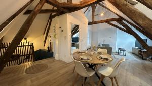 a dining room with a wooden table and white chairs at L'ombrelle in Chablis