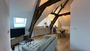 a living room with a blue couch and a kitchen at L'ombrelle in Chablis