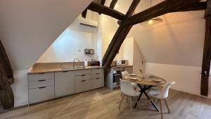 a kitchen and dining room with a table and chairs at L'ombrelle in Chablis