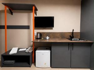 a room with a desk with a sink and a tv at Hotel Kika in Prishtinë