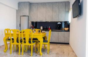 a yellow dining room table with yellow chairs in a kitchen at Vickys Apartment Diakopto in Diakopto +6 photos