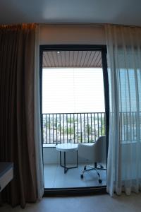 a room with a window with a table and a balcony at Hotel Kalyani Landmark in Elūru