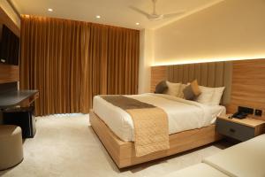 a bedroom with a large bed and a desk at Hotel Kalyani Landmark in Elūru +20 photos