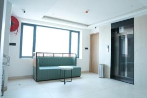 a living room with a green couch and a table at Hotel Kalyani Landmark in Elūru