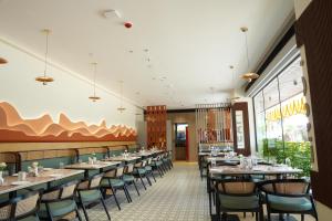 a dining room with long tables and chairs at Hotel Kalyani Landmark in Elūru