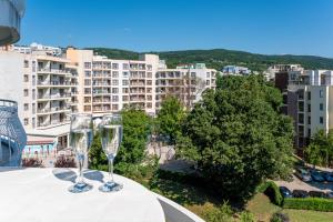 Zwei Weingläser auf einem Tisch mit Blick auf eine Stadt in der Unterkunft Prestige Grand Hotel & Aquapark - All Inclusive in Goldstrand