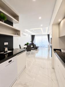 a kitchen with white cabinets and a living room at Blue life Long beach in Iskele