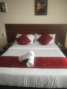 a hotel room with a large white bed with red pillows at Hidden Gem With Accomodation, Restaurant, Bar & Spa in Nairobi