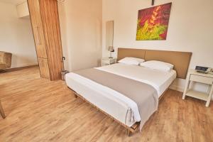 ein Schlafzimmer mit einem großen weißen Bett und einem Holzboden in der Unterkunft Kardes Hotel in Bursa