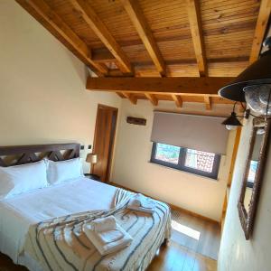 a bedroom with a bed in a room with wooden ceilings at Casa Fornos de Amor in Fornos de Algodres