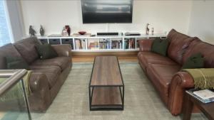 a living room with two brown couches and a coffee table at The Owlery in Fort William