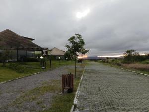 a cobblestone road with a bench on the side at Flat em Gravatá -Villa Monte Castelo - 2 quartos- Ao Lado da Área de Lazer e das piscinas in Gravatá