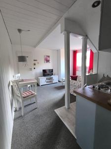 a kitchen and a living room with a table at Casa LuVilla in Braunlage