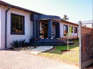 a house with a blue front door and a fence at Matsamo Lakeview Lodge in Schoemansdal