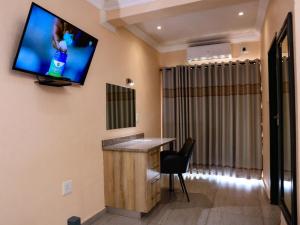 a hotel room with a flat screen tv on the wall at Matsamo Lakeview Lodge in Schoemansdal