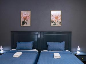 two beds in a bedroom with blue sheets and two pictures on the wall at Matsamo Lakeview Lodge in Schoemansdal +49 photos
