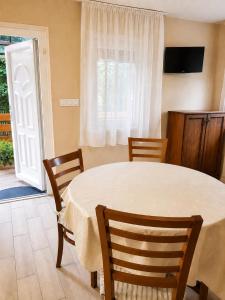 a dining room with a table and chairs and a window at Pákász Nyaralóház in Tiszafüred