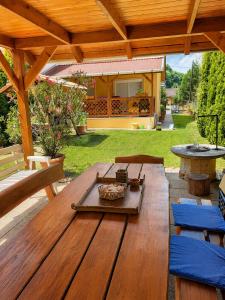 a wooden table in a backyard with a wooden roof at Pákász Nyaralóház in Tiszafüred