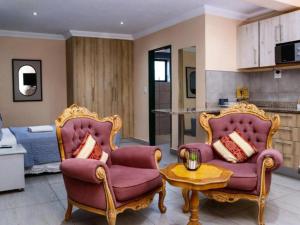 a living room with two chairs and a table at Matsamo Lakeview Lodge in Schoemansdal