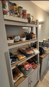 a pantry filled with lots of food on shelves at Wayside Cottage Gairloch Room Accommodation in Gairloch +16 photos