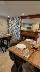 a wooden table with plates and cups on top of it at Wayside Cottage Gairloch Room Accommodation in Gairloch