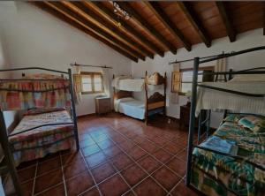 a room with three bunk beds and a tiled floor at Casa Rural La Saucedilla in Archidona +30 photos