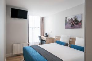 a hotel room with a bed and a desk at Hotel Library Amsterdam in Amsterdam