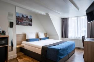a hotel room with a bed and a window at Hotel Library Amsterdam in Amsterdam