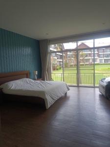 a bedroom with a bed and a large window at Bonanza in Ban Khanong Phra Klang (1)