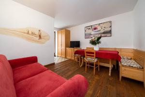 a living room with a red couch and a table at Residence Miramonti in Daiano