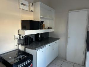 a small kitchen with a sink and a microwave at Suite Dreams Cute Studio Flat in Panorama +8 photos