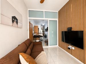 a living room with a couch and a flat screen tv at Seaside Escape Birzebbuga in Birżebbuġa