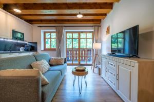 a living room with a blue couch and a tv at Apartmány Jezerné in Velké Karlovice