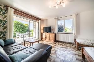 a living room with a couch and a tv at Gîte Du Noiret in Cruseilles