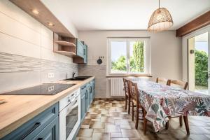 a kitchen with blue cabinets and a table with chairs at Gîte Du Noiret in Cruseilles