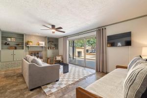 a living room with a couch and a ceiling fan at Aspen Pool House- 1 Mile From OU in Norman