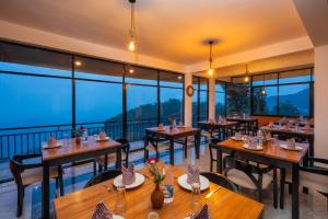 a restaurant with tables and chairs and large windows at leisure Mount View in Haputale