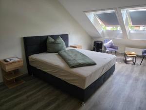 a bedroom with a large bed with two windows at Meisterjäger Akademie in Mellrichstadt