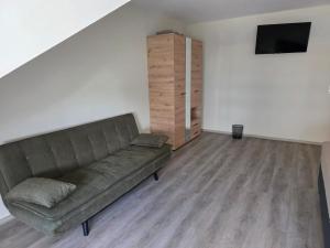 a living room with a couch and a flat screen tv at Meisterjäger Akademie in Mellrichstadt