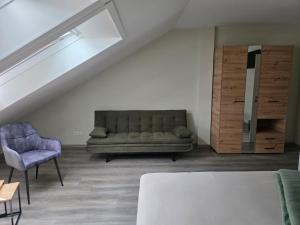 a living room with a couch and a chair at Meisterjäger Akademie in Mellrichstadt