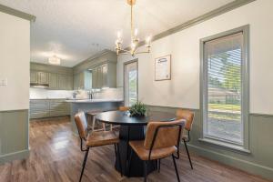 a kitchen with a table and chairs in a room at Aspen Pool House- 1 Mile From OU in Norman