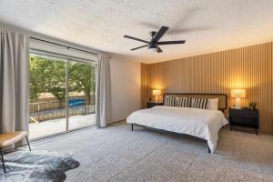 a bedroom with a bed and a ceiling fan at Aspen Pool House- 1 Mile From OU in Norman +31 photos