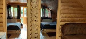 a bedroom with two beds in a log cabin at Будиночок улюблений in Shirokoye
