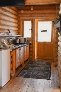 a kitchen in a log cabin with a door at Будиночок улюблений in Shirokoye