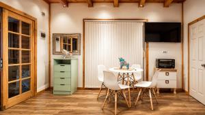 a dining room with a table and white chairs at Tiny house in Coñaripe
