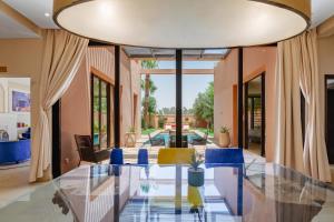 a dining room with a glass table and blue chairs at Al Maaden Villa Hotel & Spa in Marrakesh