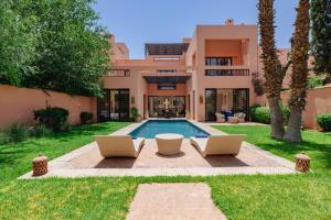 a house with two laptops in front of a pool at Al Maaden Villa Hotel & Spa in Marrakesh