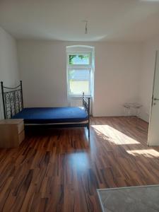an empty room with a bed and a window at Spacious Heritage Apartment for Groups in Bruck an der Leitha