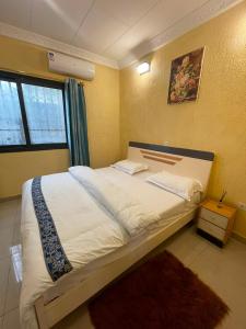 a bedroom with a large bed in a room at Résidences Quezia in Libreville