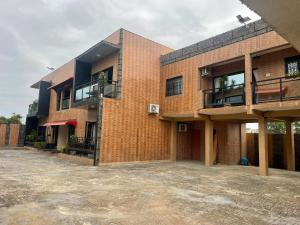 an empty parking lot in front of a brick building at Résidences Quezia in Libreville